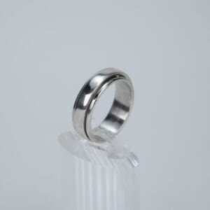 Silver ring on clear display stand.