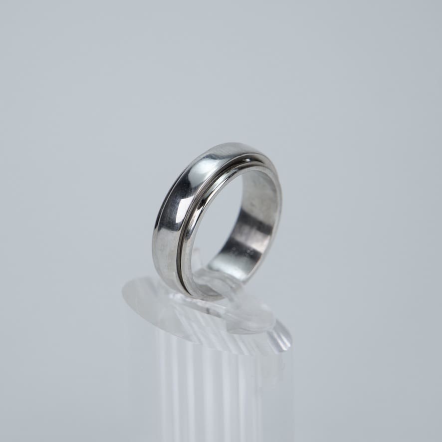 Silver ring on clear display stand.