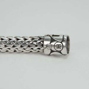 Silver woven bracelet with decorative clasp.