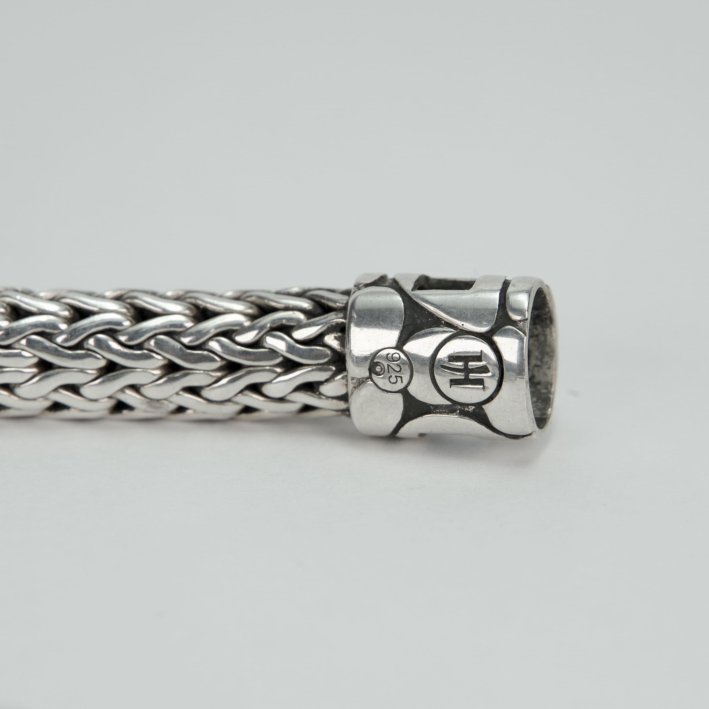 Silver woven bracelet with decorative clasp.