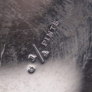 Metal surface with "6 1/4 PINTS" engraving.