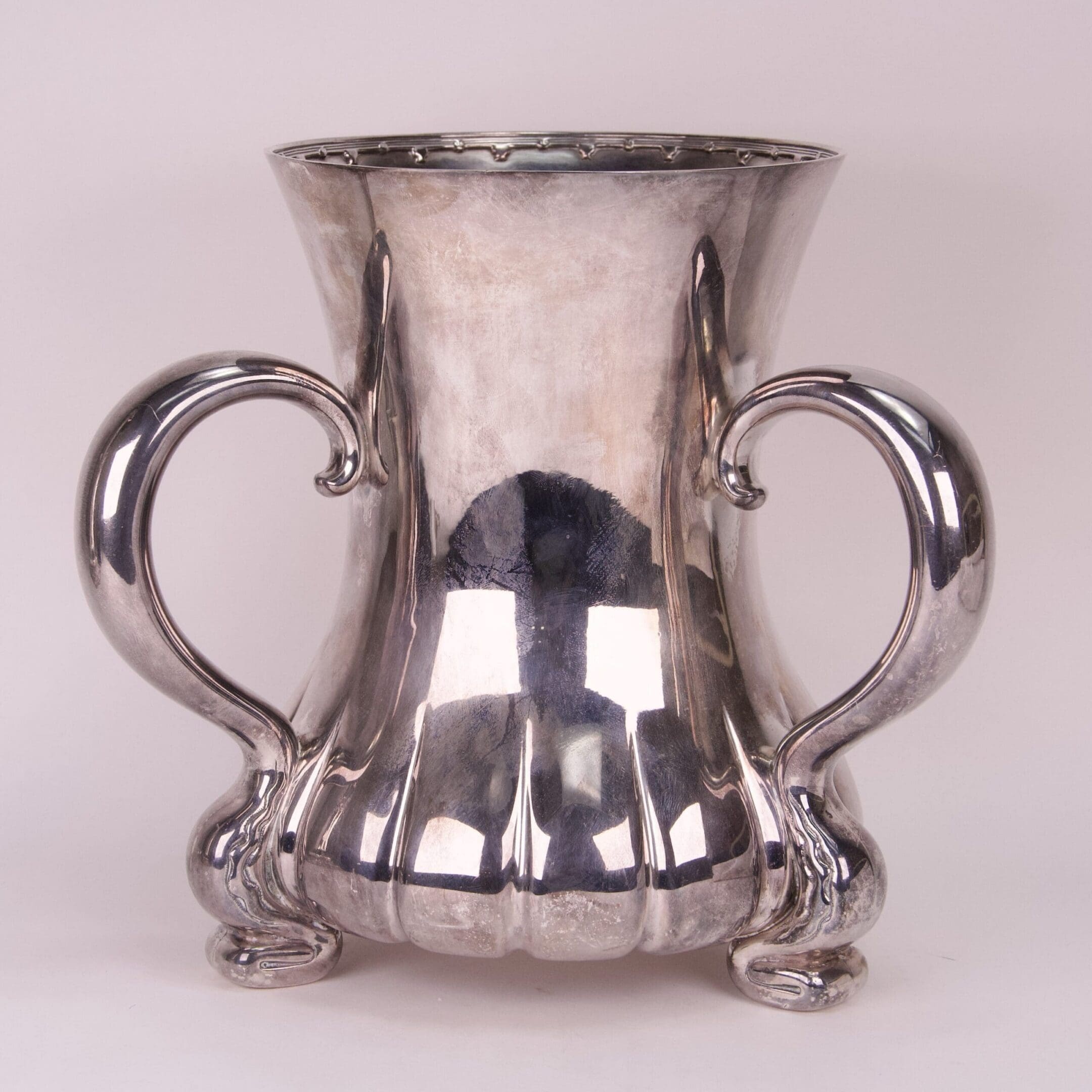 Silver decorative vase with ornate handles.