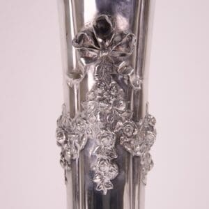 Ornate silver vase with floral details.
