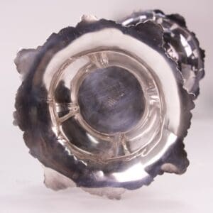 Bottom view of a silver ornate candleholder.