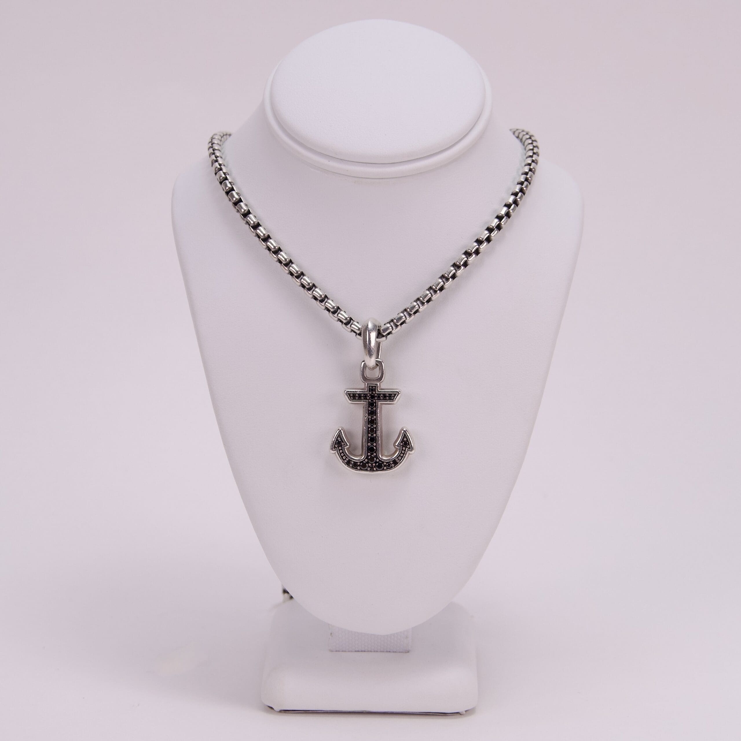 Anchor pendant necklace on display stand.