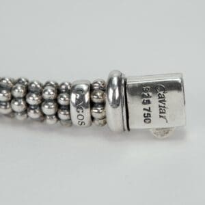Silver beaded bracelet with engraved text.