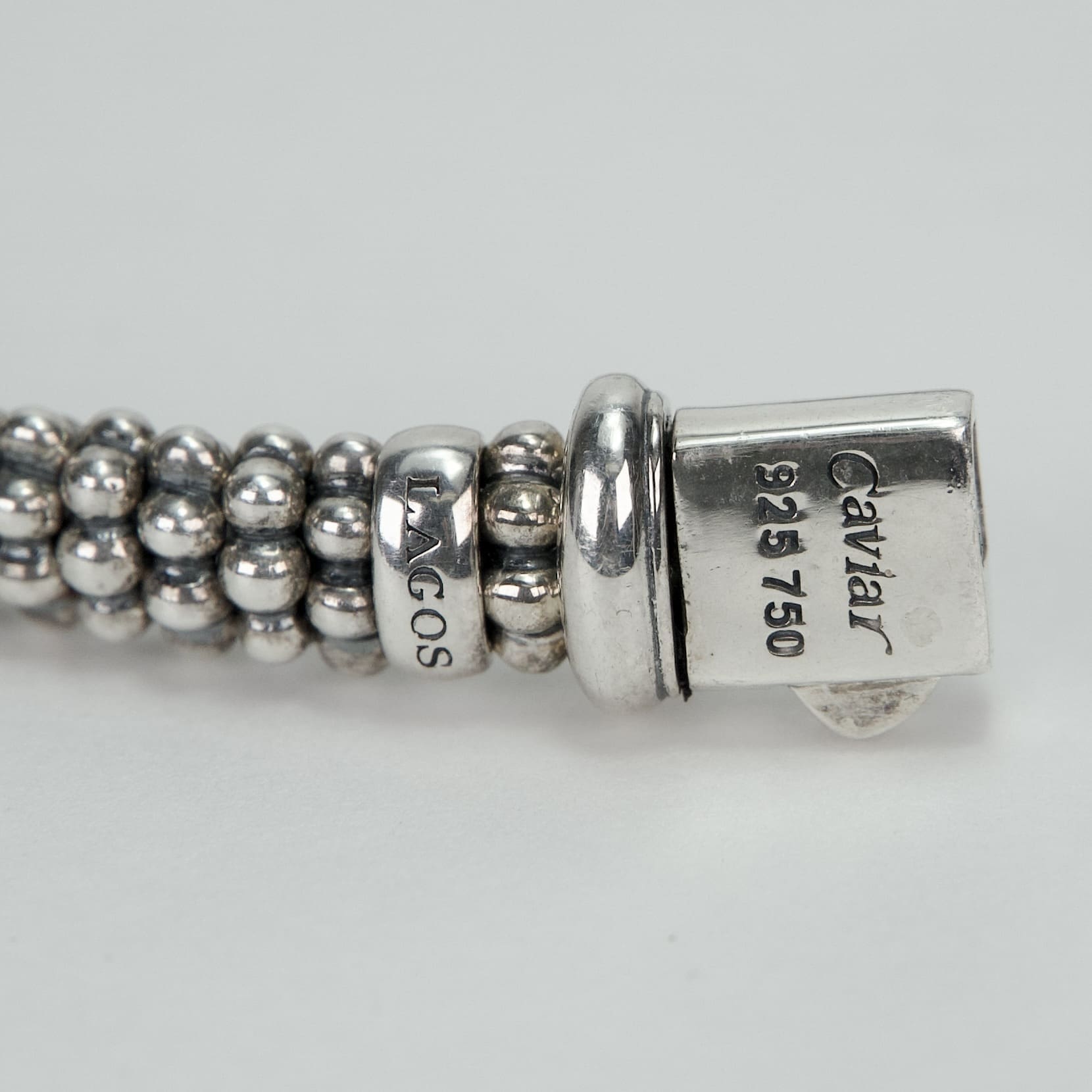 Silver beaded bracelet with engraved text.