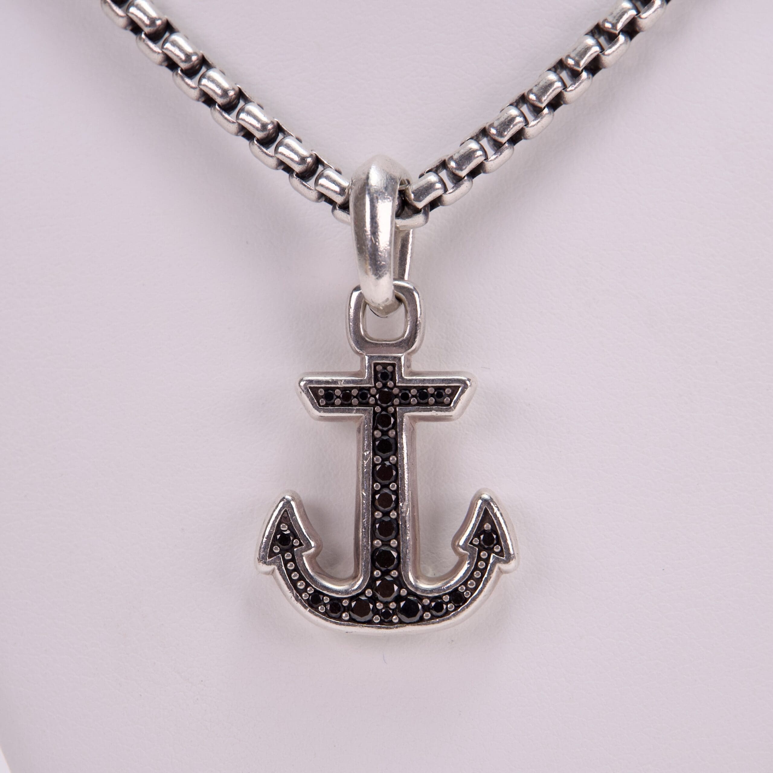 Anchor pendant on silver chain necklace.