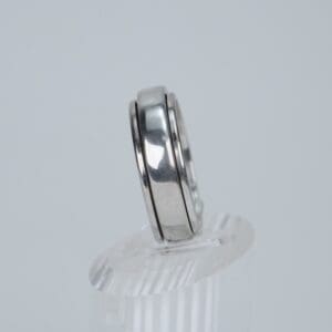 Silver ring on clear display stand.