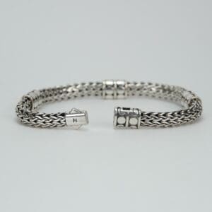 Silver woven bracelet with decorative clasps.