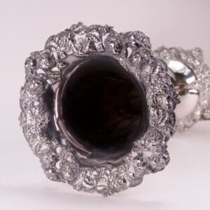 Intricate silver goblet with ornate floral design.