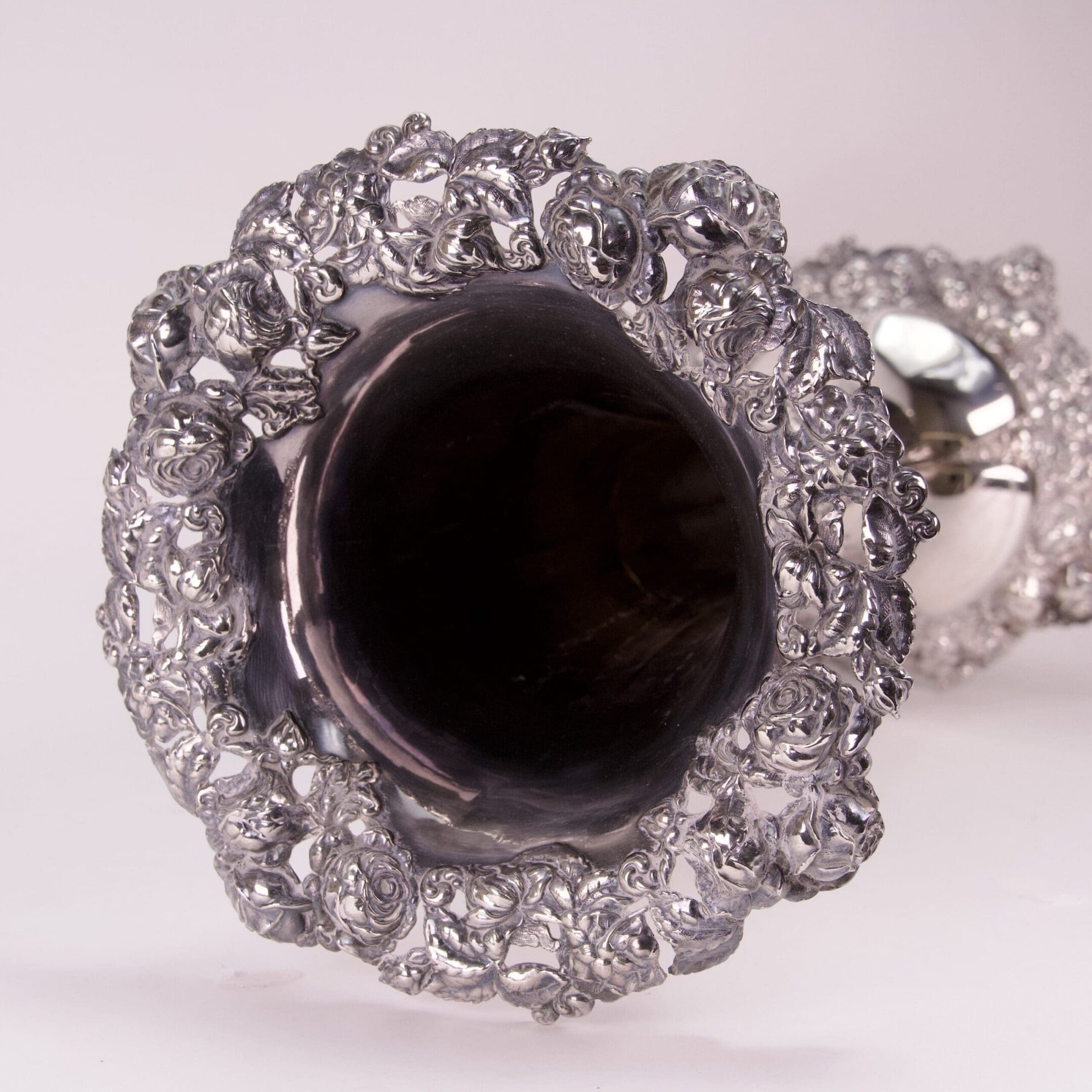 Intricate silver goblet with ornate floral design.