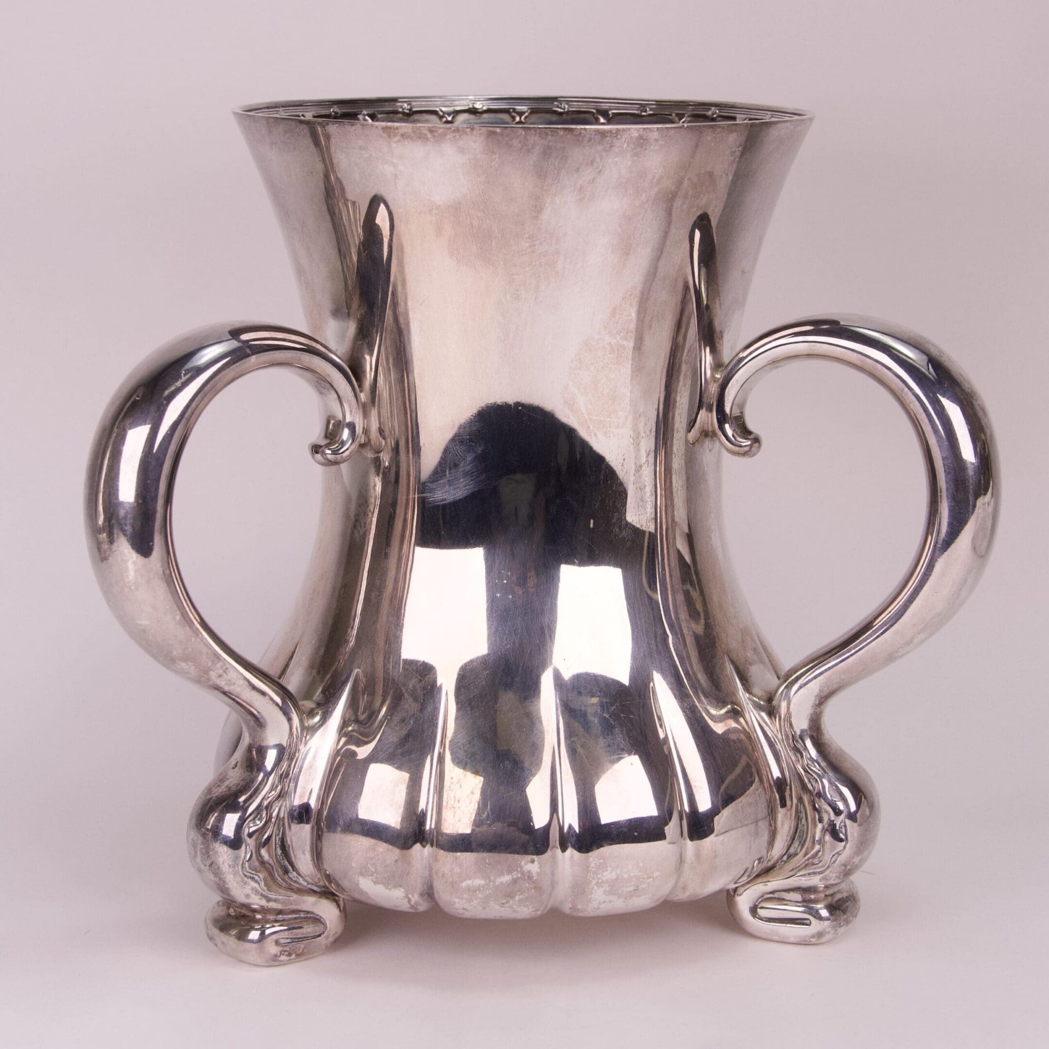 Silver decorative vase with two ornate handles.