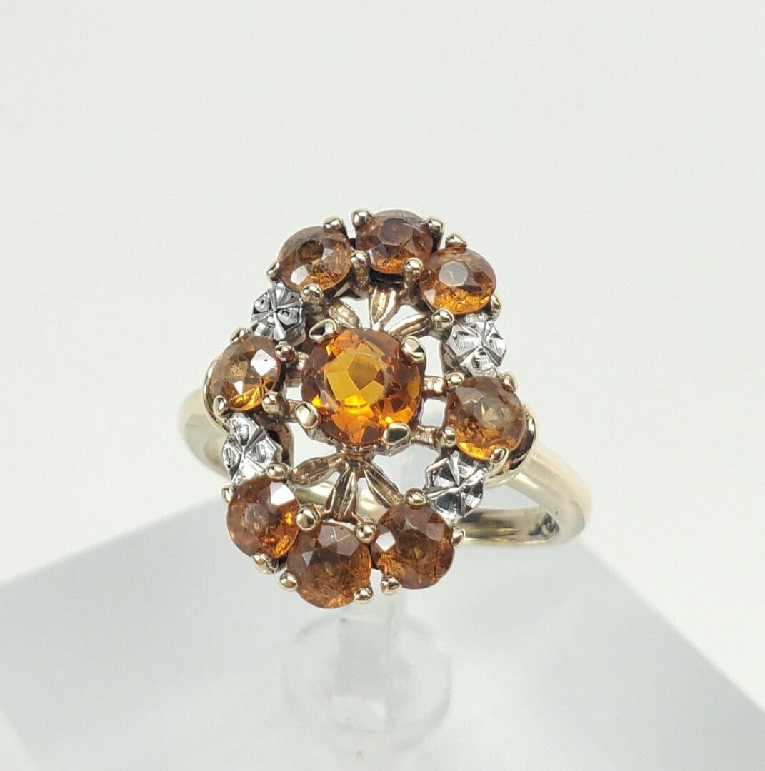 Gold ring with orange gemstones and diamonds.