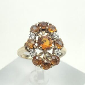 Gold ring with orange gemstones and diamonds.
