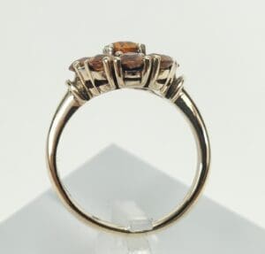 Gold ring with orange gemstone accents.