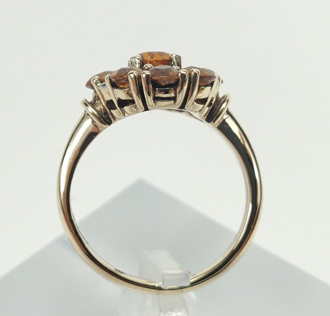 Gold ring with orange gemstone accents.