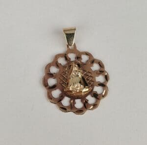 Gold pendant with intricate religious design.