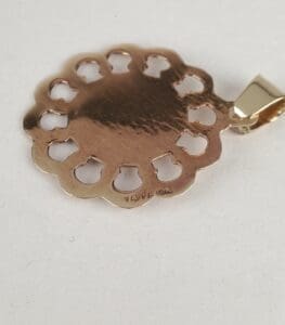 Gold pendant with circular cutout design.