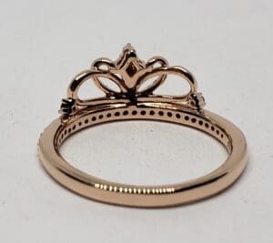 Gold ornate ring with intricate crown design.