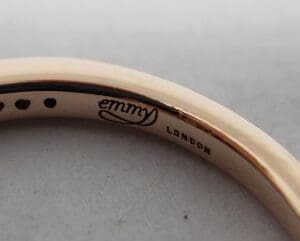 Gold ring with "Emmy London" engraving.