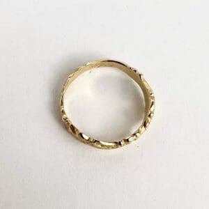 Gold textured ring on white background.