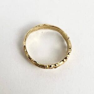Gold textured ring on white background.