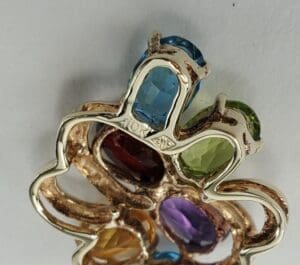 Colorful gemstone pendant with intricate metal design.