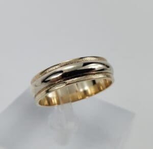Gold band ring on display stand.