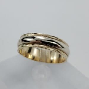 Gold wedding ring on white background.