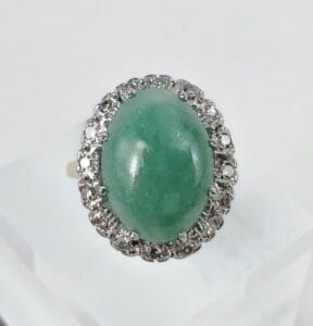 Green gemstone ring with diamond accents.