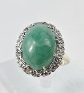 Green gemstone ring with diamond accents.