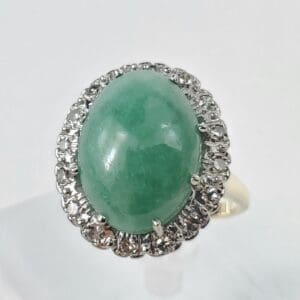 Green gemstone ring with diamond accents.