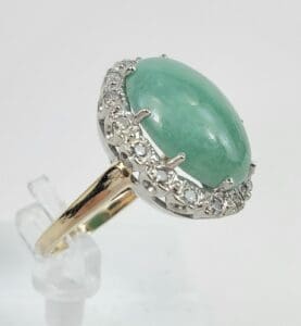 Gold ring with green gemstone and diamonds.
