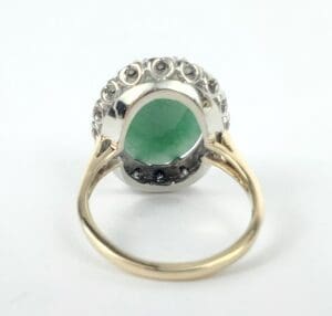 Gold ring with green gemstone and diamonds.