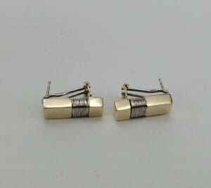 Gold and silver rectangular cufflinks on display.