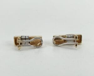 Gold and silver cufflink pair displayed.