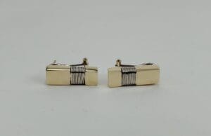 Gold cufflinks with black stripe design.