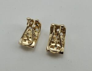 Gold earrings with intricate lattice design.