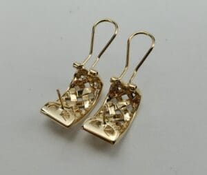 Gold earrings with intricate woven design.