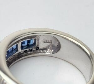 Silver ring with blue gemstones and engraving.