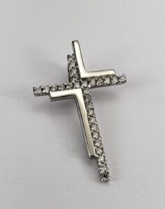 Diamond-studded cross pendant on white background.