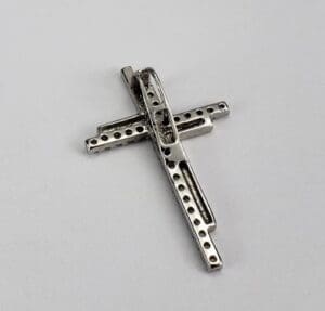 Metallic cross with perforated design.