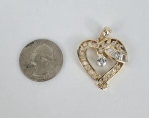 Heart-shaped pendant beside a coin.
