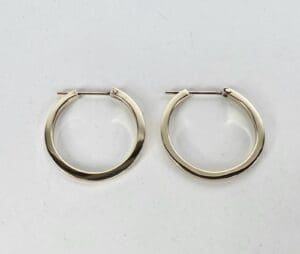 Gold hoop earrings on white background.