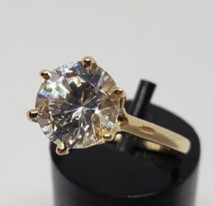 Gold ring with large round diamond solitaire.