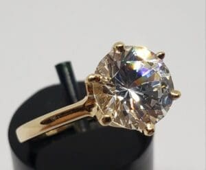 Gold ring with large round diamond solitaire.
