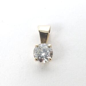 Gold pendant with a round diamond.
