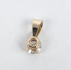 Gold pendant with clear gemstone setting.