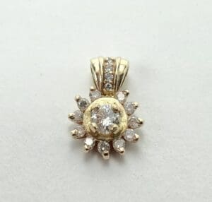Gold and diamond sunburst pendant on display.